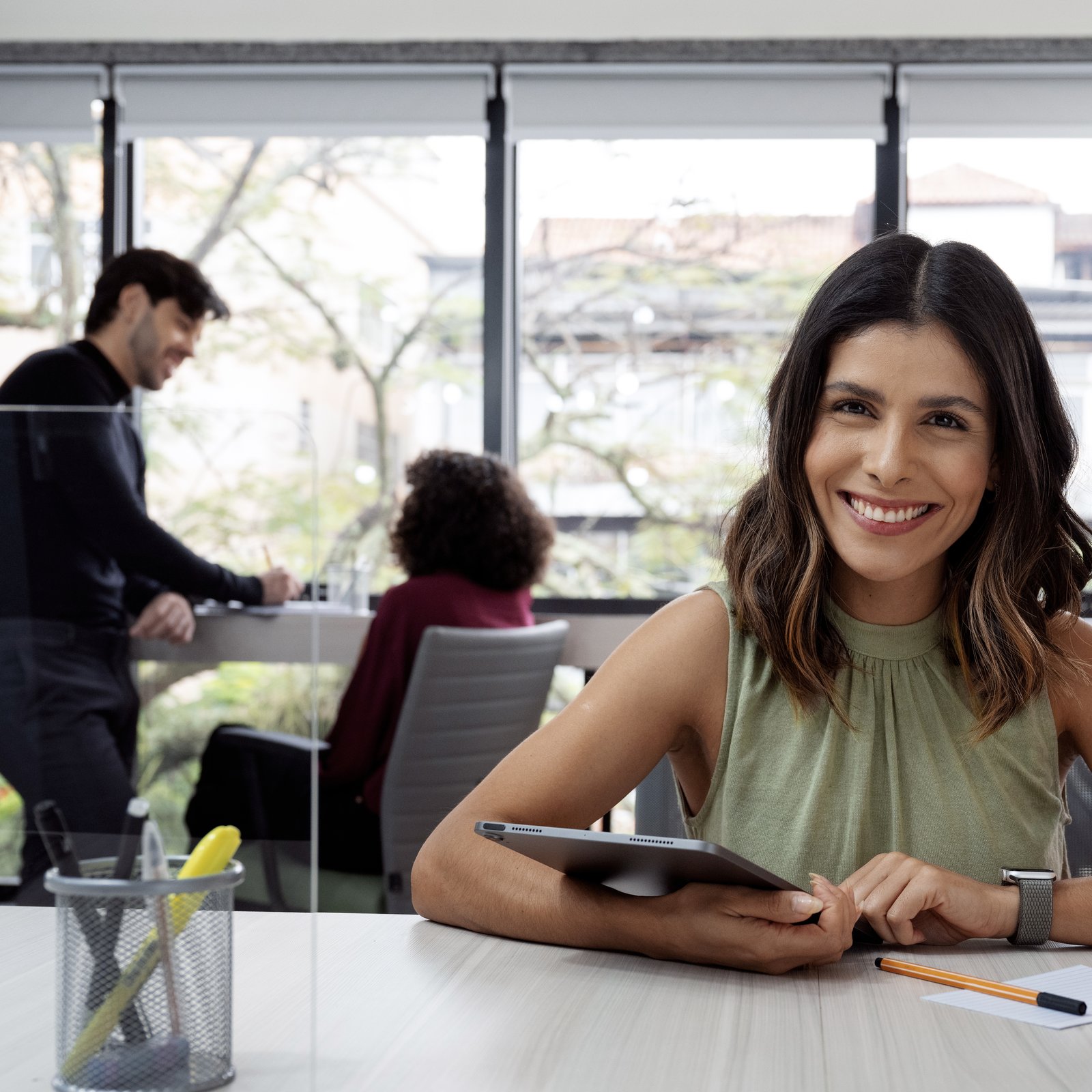 Latin American operations professional with her team at a modern office