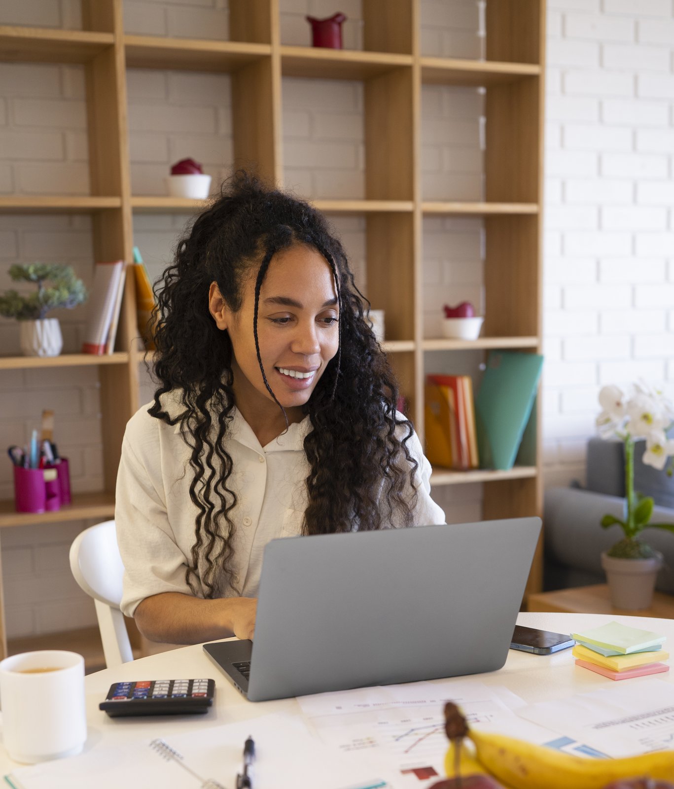 Latin American operations professional smiling while working at her laptop