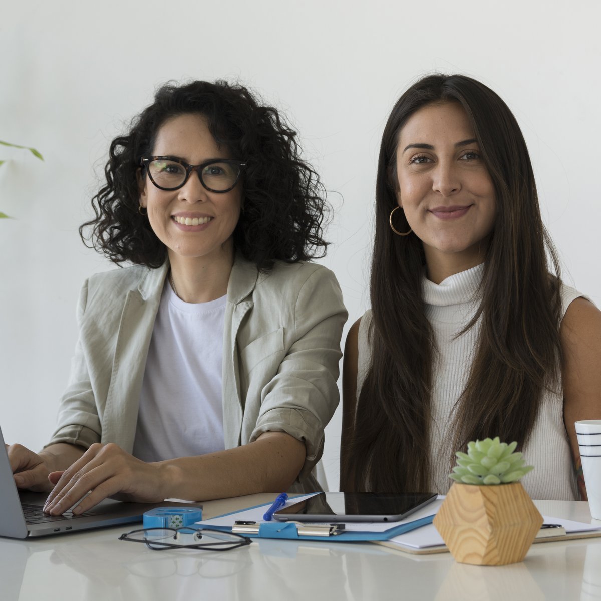 Two operators working together with AI tools — humans + tech compounding